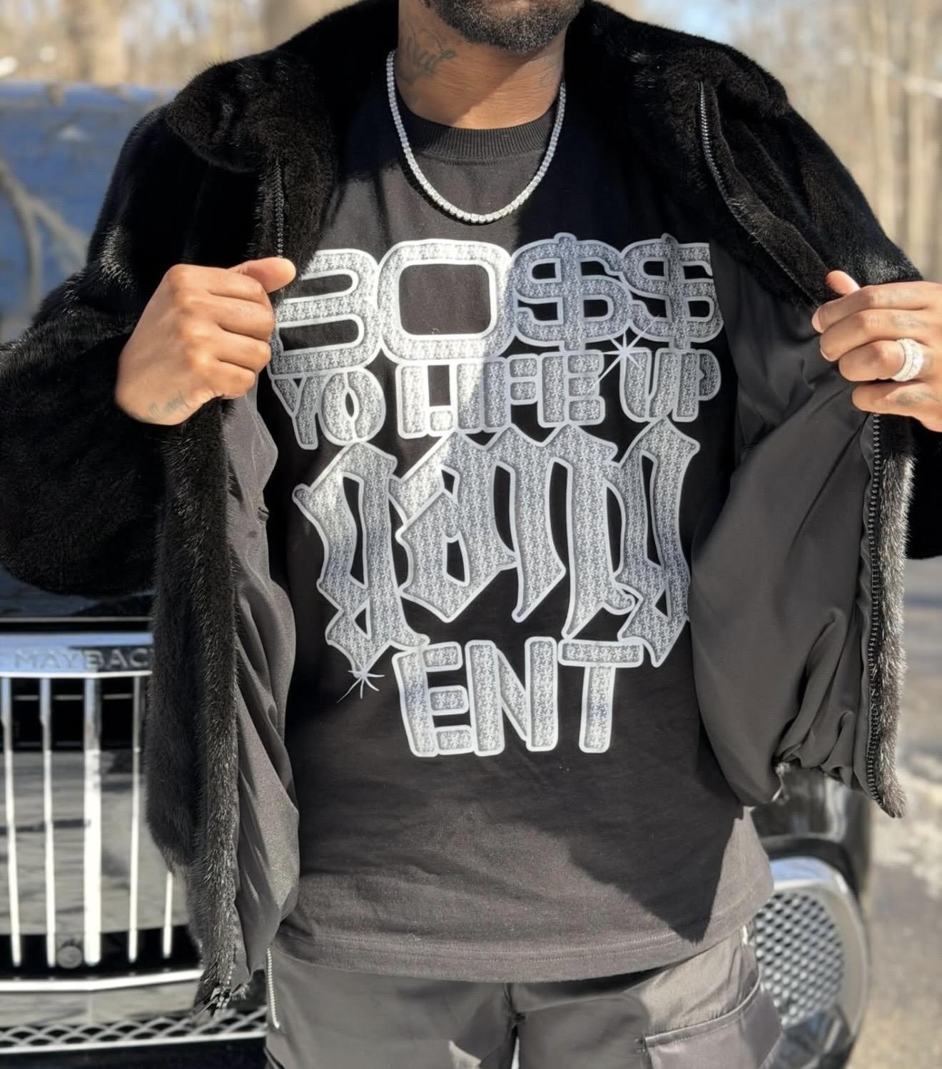 Person wearing a black shirt with a large chrome BYLUG graphic